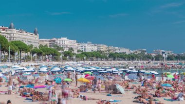 Fransa 'nın güzel bir yaz gününde Fransız Riviera' sında Cannes 'daki renkli eski kasaba binaları ve plajlar. Azur denizi, kumdaki insanlar