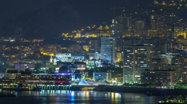 Monte Carlo 'nun şehir manzarası, Monaco, gece vakti. Akşam sisi ve binaların gece aydınlığı. Limandaki yatlar. Kaptan Martin 'den üst görünüm