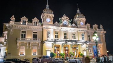 Monte Carlo 'da Grand Casino, Monaco' da gece vardiyası. Tarihi bina. Girişi olan ön manzara. Avuç içi yanda. Akşam aydınlatması