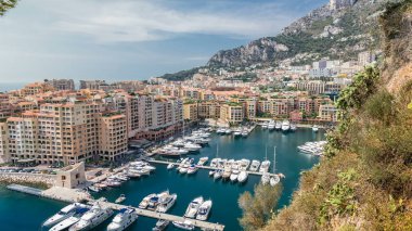 Fontvieille zaman diliminin panoramik görüntüsü - Monaco 'nun yeni bir bölgesi. Tekneler, limanda yatlar ve yüksek katlı bir apartman kompleksi. Monako Prensliği Fransız Rivierası 'nda bulunan bağımsız bir şehir devletidir.