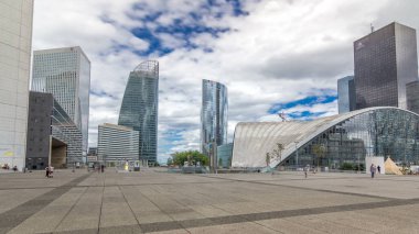 Savunma timelapse hyperlapse modern iş ve Finans Merkezi Paris'te highrise binalar ve Kongre Merkezi ile gökdelenler. Grande Arche yakınındaki Meydanı'na görüntüleyin. Yaz günü mavi bulutlu gökyüzü. Modern kuleleri yansımalar.