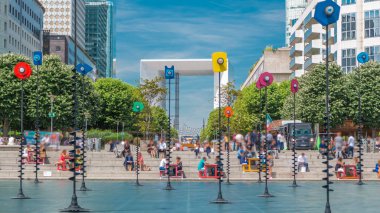 Gökdelenler La Defense timelapse - Modern iş ve konut alanı, Esplanade Çeşmesi. Yeşil ağaçlar, mavi bulutlu gökyüzü güneşli yaz günü. Paris, Fransa