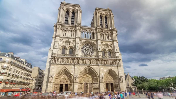 Front view of Notre-Dame de Paris timelapse hyperlapse is a medieval Catholic cathedral on the Cite Island in Paris, France. Long queue of tourists. Cloudy sky at summer day