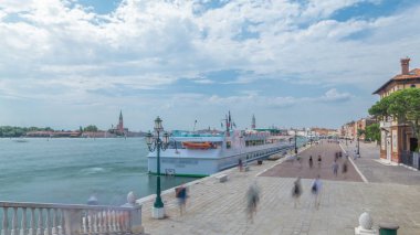 Riva degli Schiavoni timelapse turistler İtalya San Marco Venedik ile Gezinti görünümünü. San Giorgio Maggiore katedral arka plan üzerinde. Köprüsü'nden görüntülemek