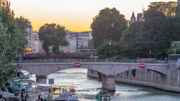 Río y puente cerca de la catedral de Notre Dame De Paris día a noche timelapse después de la puesta del sol. — Vídeo de stock