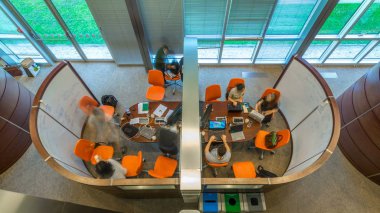 Modern ofis timelapse genç yaratıcı insanlar. Grup Genç iş adamları ve öğrencilerin dizüstü bilgisayar, tablet, akıllı telefon, Not defteri ile birlikte çalışıyoruz. Coworking başarılı takımı. Serbest. Üstten üstten görünüm