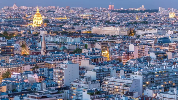 Paris 'teki evlerin çatılarının üstündeki hava panoraması gece gündüz geçiş zamanı. Günbatımından sonra gece manzarası ve diğer manzaralar aydınlandı.