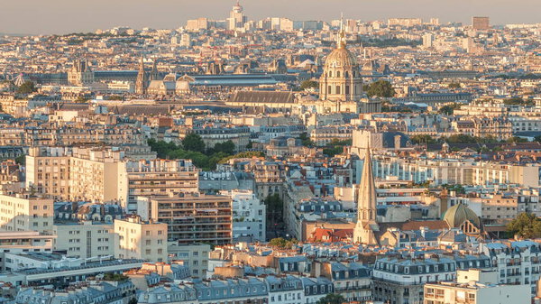 Aerial panorama above houses rooftops in a Paris timelapse. Evening view with les invalides bebore sunset