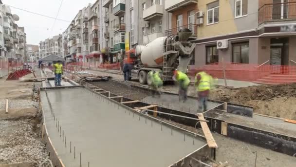 Betongarbeten för vägkonstruktion underhåll med många arbetare och mixer timelapse — Stockvideo