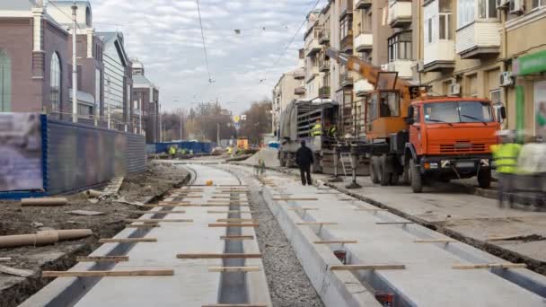 Tramvay rayları üzerinde yol timelapse beton tabaklarda vinç onların kamyondan boşaltma aşamasında. — Stok video