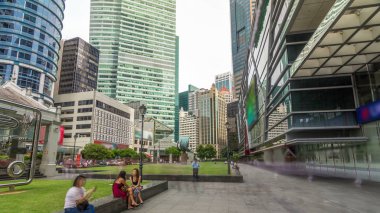 Gökdelen Raffles Place Singapore Finans Merkezi timelapse hyperlapse kuleleri. Yeşil çimler. Etrafta dolaşan insanlar