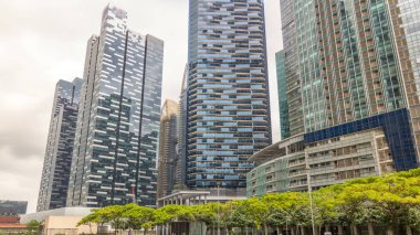 Singapur şehir manzarası. Modern megalopolis timelapse hyperlapse şehir merkezindeki gökdelenler ofis binaları. Cam yüzey ve bulutlar gökyüzü üzerinde yansımalar