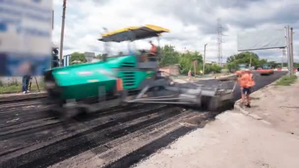 A finiser kövezőmunkás, aszfalt simító vagy a megnyitva gép elhelyezése egy réteg aszfalt alatt egy repaving építési projekt timelapse — Stock videók