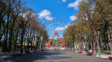 Kharkov timelapse hyperlapse, Ukrayna içinde dönme dolap Gorki Central Park Kültür ve eğlence. Bulutların üstünde mavi bir gökyüzü güneşli gün, ana sokaktan görüntülemek