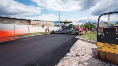 A paver finisher, asphalt finisher or paving machine placing a layer of asphalt during a repaving construction project timelapse. Trucks with asphalt clipart