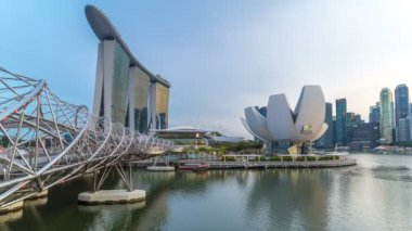 Arka plan üzerinde gece geçiş timelapse ışıklandırılmış gökdelenler ile toplantısına Singapore görünümü Helix Köprüsü. Bir yaya köprüsü Marina merkezi Marina Güney ile bağlama Helix köprüdür