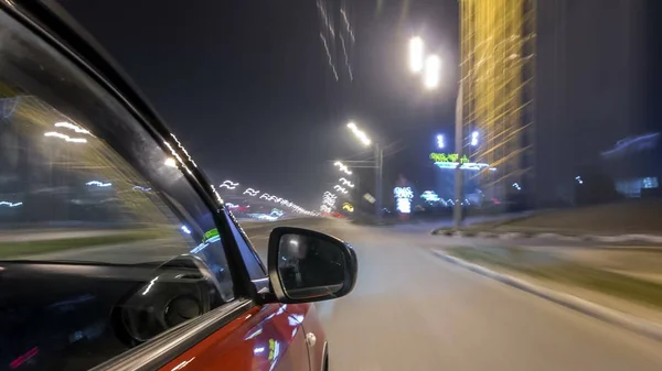 Drivelapse urban look from fast driving car at a night avenue in a city timelapse hyperlapse, road with lights reflected on car at high speed. Rapid rhythm of a modern city.