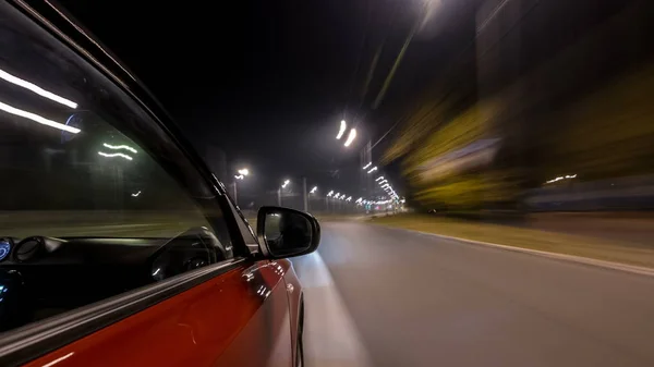 Drivelapse urban look from fast driving car at a night avenue in a city timelapse hyperlapse, road with lights reflected on car at high speed. Rapid rhythm of a modern city.