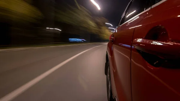 Drivelapse urban look from fast driving car at a night avenue in a city timelapse hyperlapse, road with lights reflected on car at high speed. Rapid rhythm of a modern city.