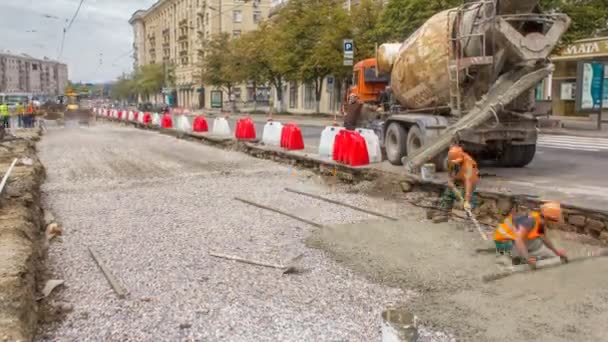 Trabajos de hormigón para la construcción de mantenimiento de carreteras con muchos trabajadores y timelapse mezclador — Vídeos de Stock