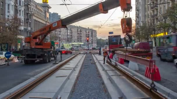 Grue mobile télescopique de construction orange déchargeant les rails de tramway du timelapse du camion . — Video