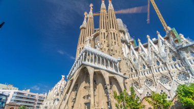 Sagrada Familia, Barselona, İspanya, timelapse hyperlapse büyük bir Roma Katolik Kilisesi. Sonbahar günü, yeşil ağaçlar, mavi bulutlu gökyüzü