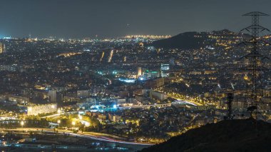 Evler ve ufuk gece timelapse denizde çatılar ile Barcelona ve Badalona manzarası. Tepenin üstüne Iberic Puig İspanya köyü açısından havadan görünümü