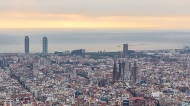 Barcelona Panoraması gündoğumu timelapse, İspanya, sırasında ışık ışınları ile bulutlu bir sabahı Carmel sığınaklar görüş. Sagrada familia Katedrali ile Hill Hava üstten görünüm. Renkli gökyüzü