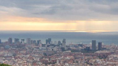 Barcelona Panoraması gündoğumu timelapse, İspanya, sırasında ışık ışınları ile bulutlu bir sabahı Carmel sığınaklar görüş. Modern binalar ile Hill Hava üstten görünüm. Renkli gökyüzü