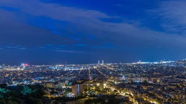 Panorama of Barcelona night to day timelapse, Spain, viewed from the Bunkers of Carmel on a cloudy morning before sunrise. Aerial top view from hill. City lights turning off