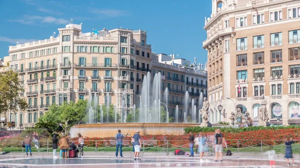 People at Placa de Catalunya or Catalonia Square timelapse a large square in central Barcelona that\'s considered to be the city centre. Fountain and flowerbed on background