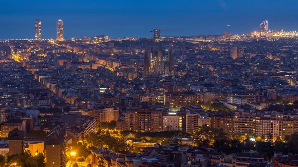 Panorama of Barcelona night to day timelapse, Spain, viewed from the Bunkers of Carmel on a cloudy morning before sunrise. Aerial top view from hill with sagrada familia cathedral. City lights turning off