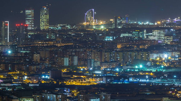 Barcelona and Badalona skyline with roofs of houses and sea on the horizon night timelapse. Aerial view from Iberic Puig Castellar Village viewpoint on top of hill