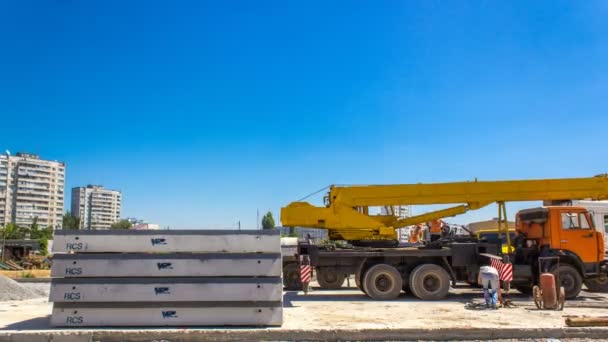 Installation de plaques de béton par grue sur le chantier de construction routière timelapse . — Video