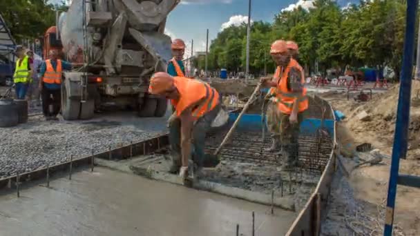 Trabajos de hormigón para la construcción de carreteras con muchos trabajadores y timelapse mezclador — Vídeos de Stock