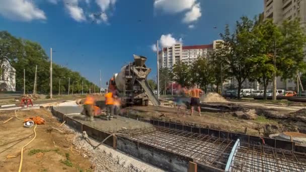 Travaux de béton pour la construction de routes avec de nombreux travailleurs et mélangeur timelapse — Video