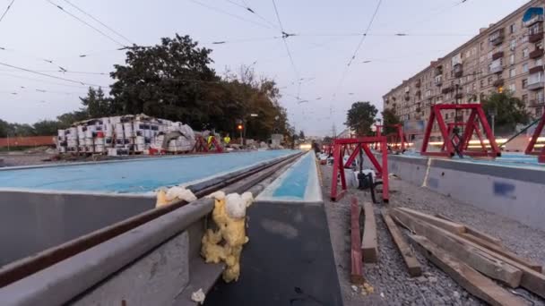 Tramvajová kolejnice na stupni jejich instalace a integrace do betonové desky na silnici timelapse hyperlapse. — Stock video