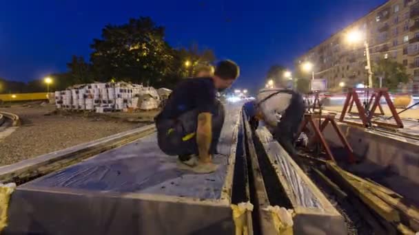 Tramvajová kolejnice na stupni jejich instalace a integrace do betonové desky na silnici timelapse hyperlapse. — Stock video