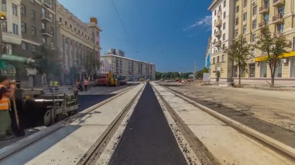 Asphaltfertiger, Walze und LKW während der Asphaltierungszeit auf der Baustelle. Straßenbaugeräte. — Stockvideo