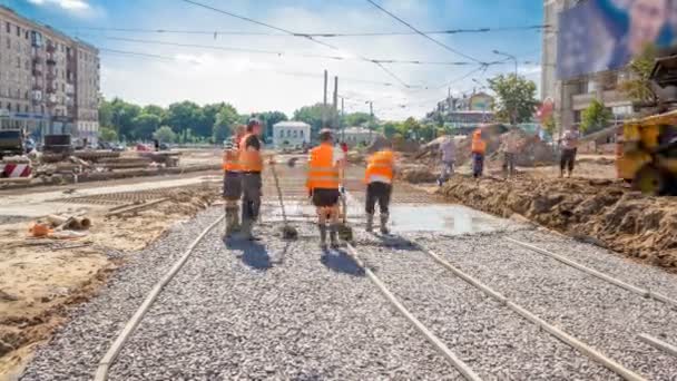 コンクリートは制服とミキサー機タイムラプスの多くの労働者と道路建設に勤めています トラムのトラックの再建 — ストック動画