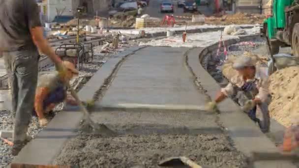 Concrete works for road construction with many workers in uniform and mixer machine timelapse. Reconstruction of tram tracks — Stock Footage Concrete Works Road Construction Many Workers Uniform Mixer Machine Timelapse Video Clip