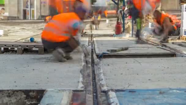 Tramvajová kolejnice ve fázi jejich instalace a integrace do betonové desky na silnici timelapse — Stock video