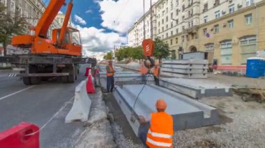 Vinç yol inşaat site timelapse hyperlapse, beton plaka yükleme. Kavganın ve üniforma ile sanayi işçileri. Sokak şehir tramvay yeniden inşası izler