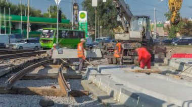 Vinç yol inşaat site timelapse, beton plaka yükleme. Kavganın ve üniforma ile sanayi işçileri. Sokak şehir tramvay yeniden inşası izler