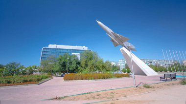 The MIG-21 plane is a monument in the square of Glory timelapse hyperlapse. Blue sky at sunny day. Aktau, Kazakhstan clipart