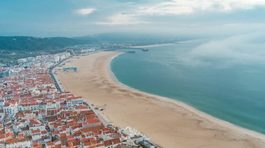Nazare panorama görünümünü füniküler kabinleri. Sis akşam gün batımı sırasında okyanus tarafından geliyor. Portekiz Nazare Atlantic Coast en popüler deniz tatil var. Nazare manzarası ve plaj sahil Nazare Sitio üzerinden.