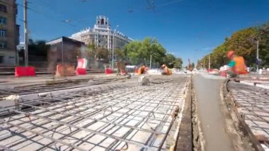 Beton yol yapım birçok işçi ve mikser timelapse hyperlapse ile çalışıyor. Harç metal takviye için dökme. Kaplama ve koruyucu filtre püskürtücü tarafından. Tramvay parça yeniden inşası