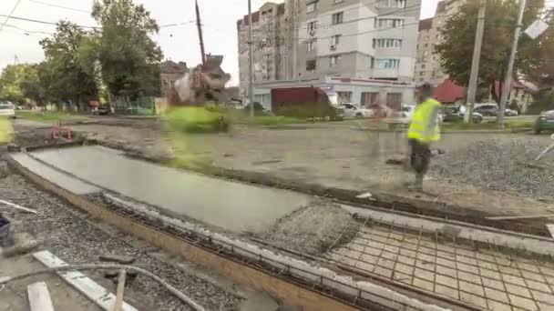 Бетонні роботи для будівництва доріг з багатьма робітниками та мікшерами — стокове відео