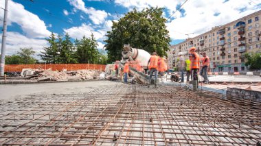Beton yol yapım birçok işçi ve mikser timelapse hyperlapse ile çalışıyor. Harç metal takviye için dökme. Tramvay parça yeniden inşası