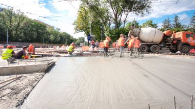 Beton yol yapım birçok işçi ve mikser timelapse hyperlapse ile çalışıyor. Harç metal takviye için dökme. Tramvay parça yeniden inşası